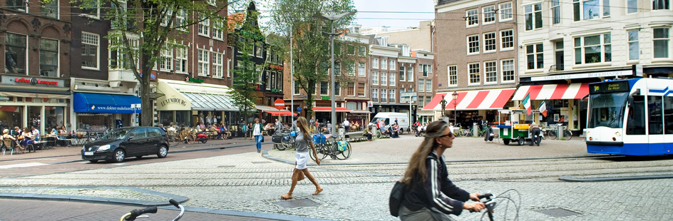 The Spui square with cyclist and a tram passing by
